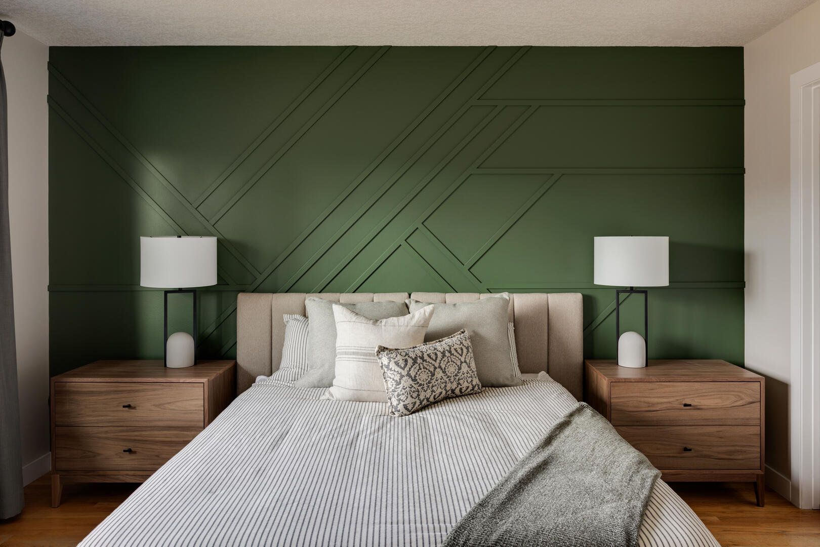 Modern bedroom with green accent wall, transitional primary bedroom with wood furniture and neutral decor