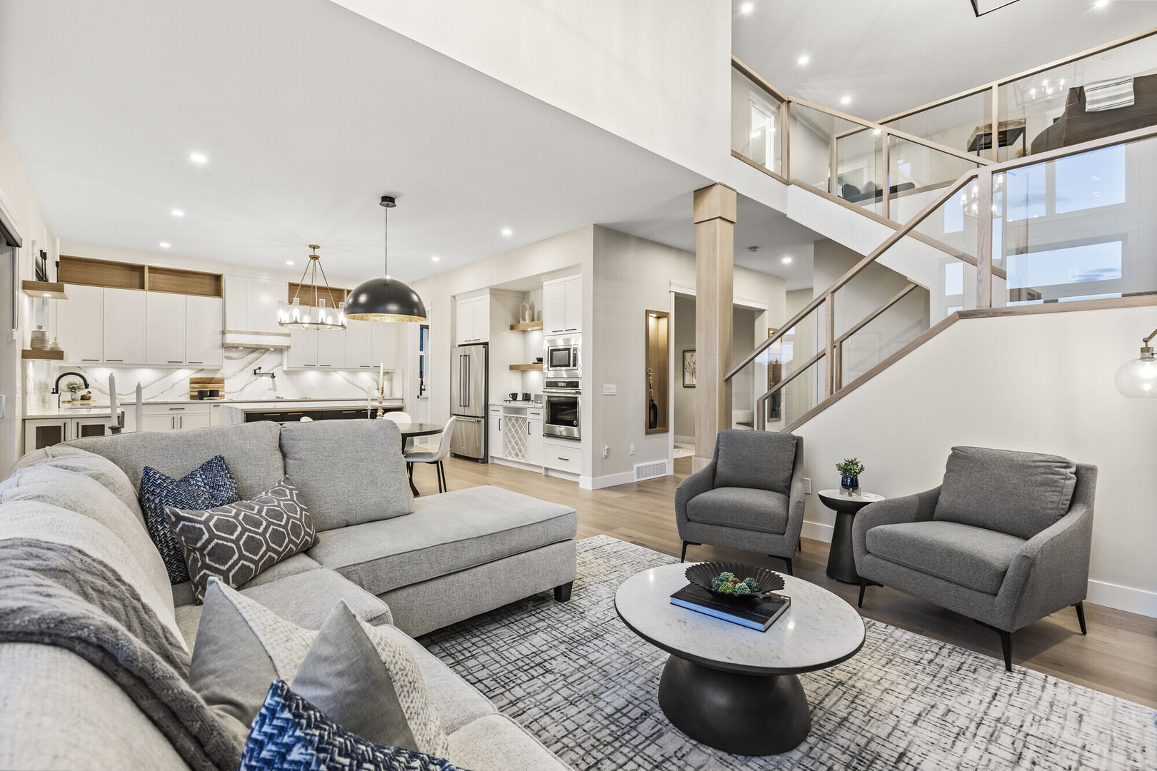 open concept modern living room, wood and glass stair railings