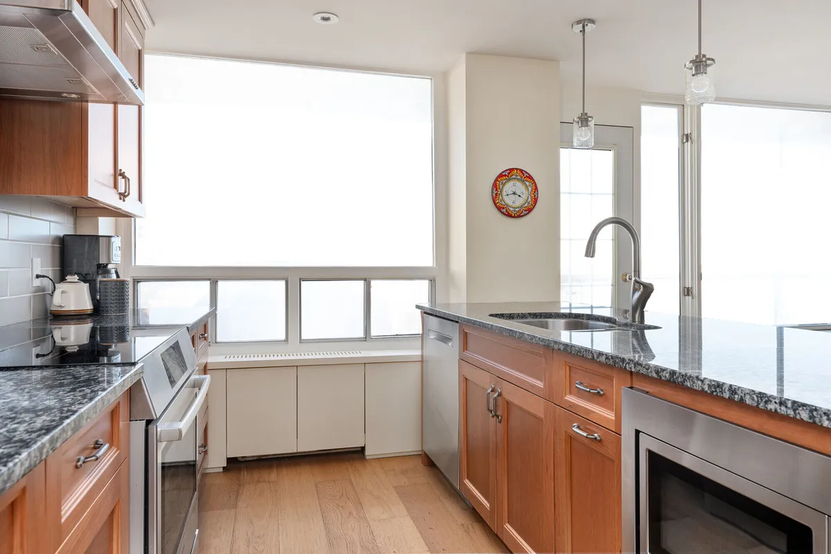 A modern light bright kitchen with orange wood cabinets Calgary southwest interior design