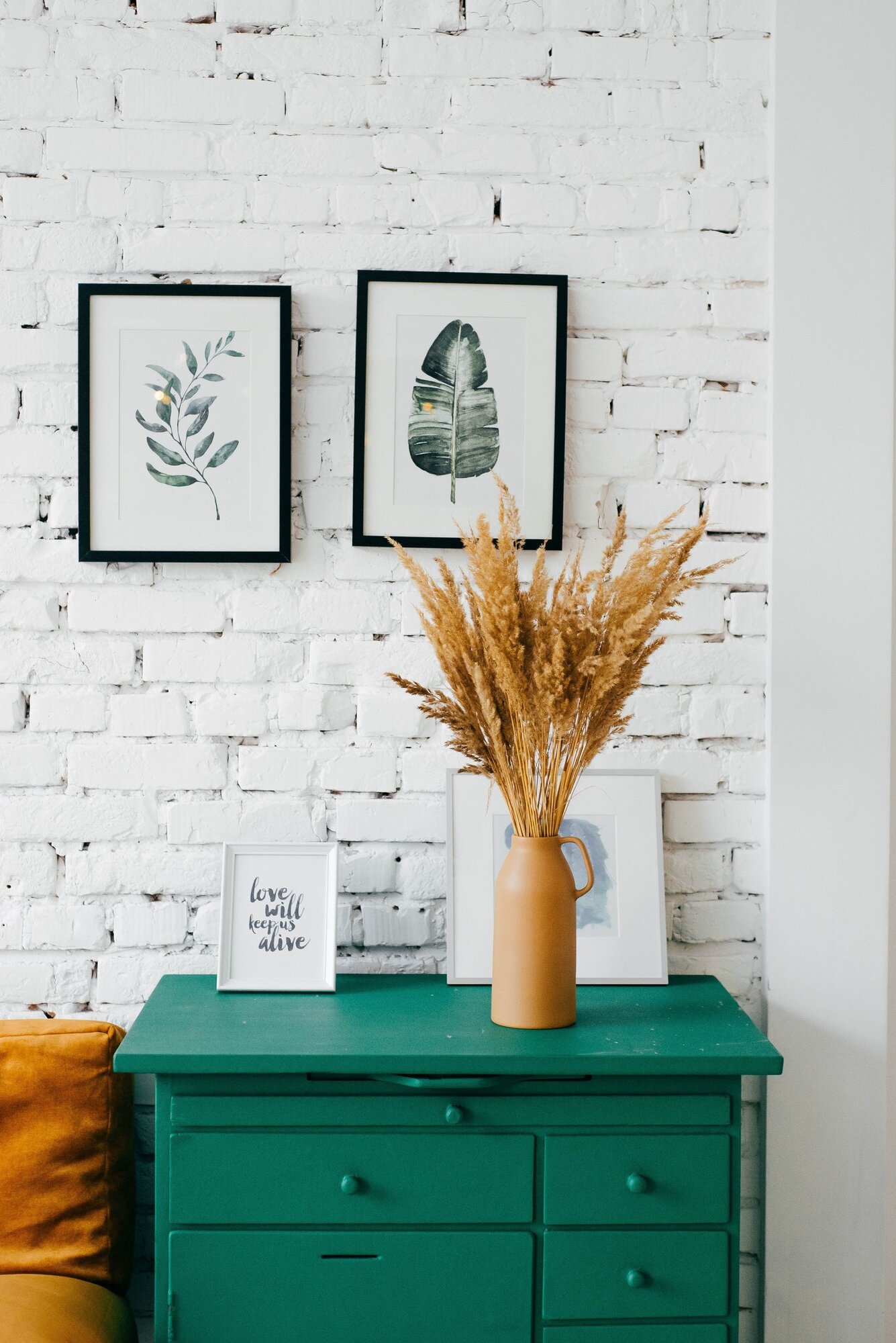 Rustic green bedside table with exposed brick