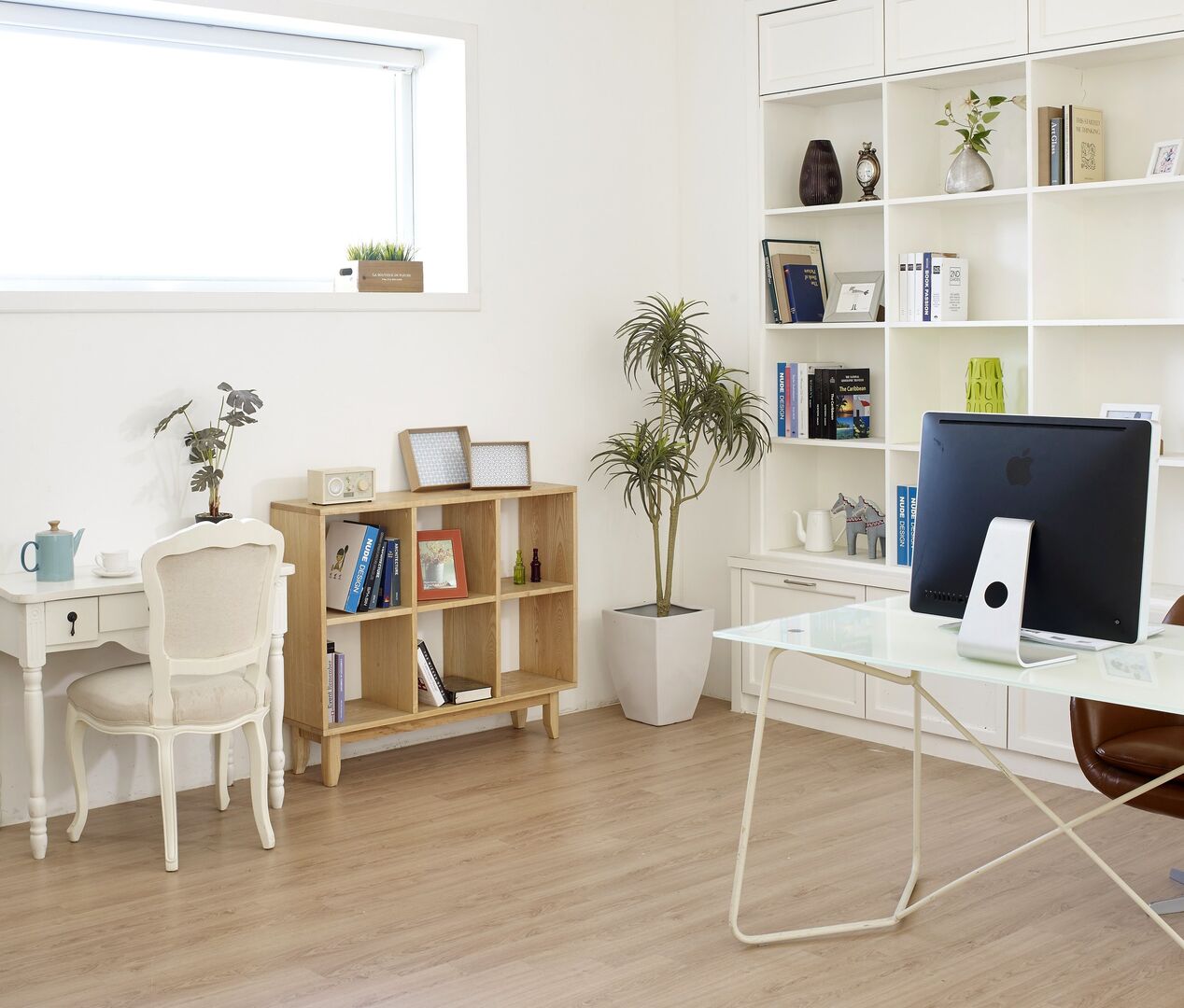 A modern home office with natural wood accents and many plants