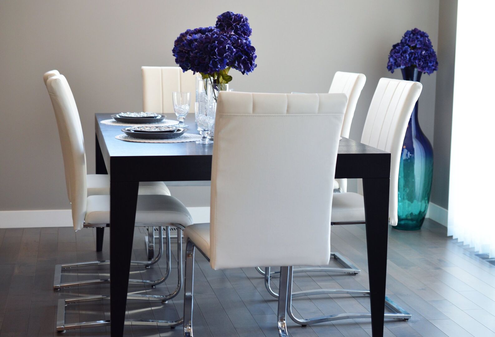 Chairs around a dining table with large purple flowers on it